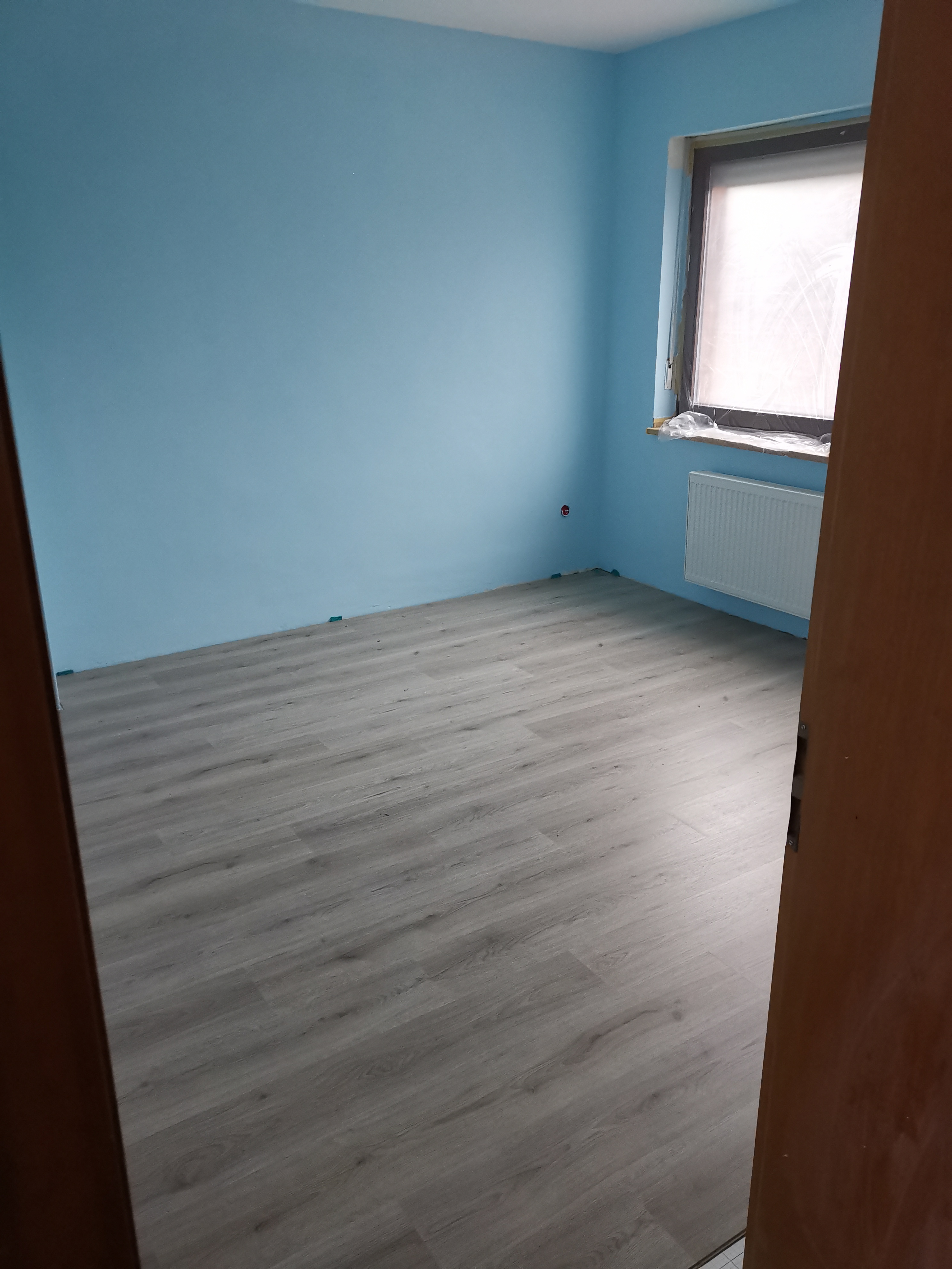 Zimmer nachher – frisch gestrichen mit neuem Boden
